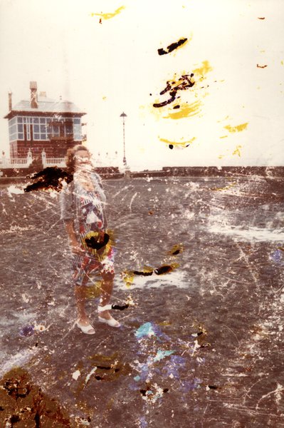 Femme sur une plage près d'un bâtiment. Image avec taches.ᴬᴵ