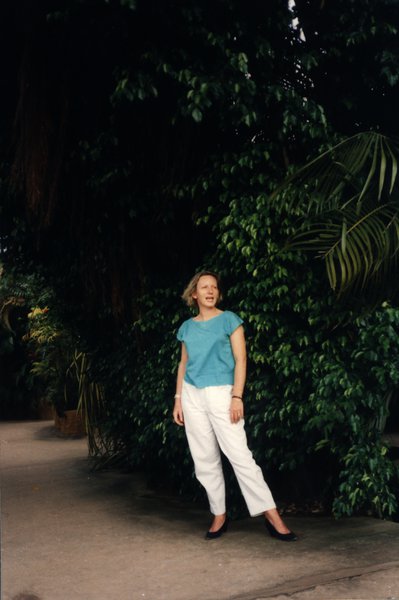 Femme debout devant une végétation tropicale dense.ᴬᴵ