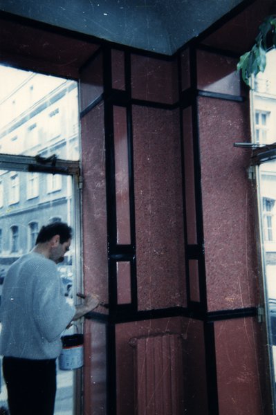 Homme peignant l'encadrement d'une porte.ᴬᴵ