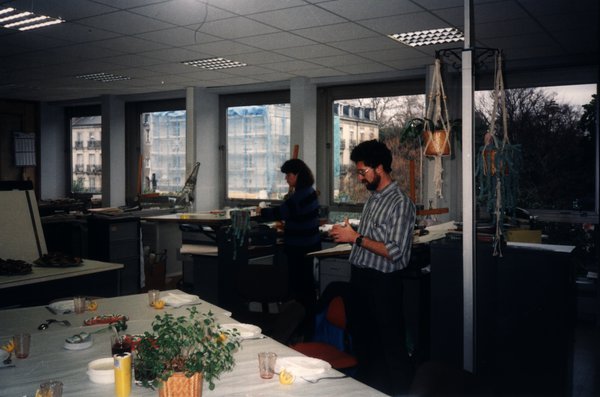 Deux personnes dans un bureau aménagé pour un repas.ᴬᴵ