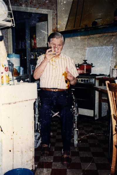 Homme âgé en fauteuil roulant dans une cuisine. Image avec taches.ᴬᴵ