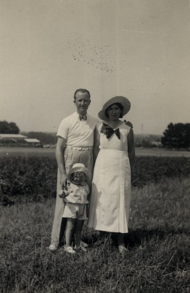 Portrait de famille dans un champ : un homme, une femme et un enfant. Noir et blanc.ᴬᴵ