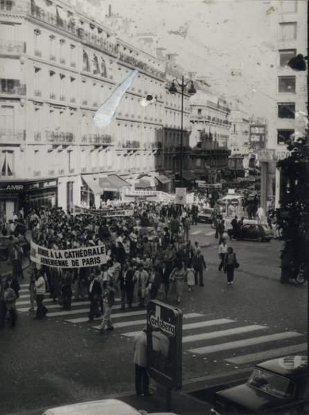 Foule avec manifestants dans la rue et voitures. Noir et blanc.