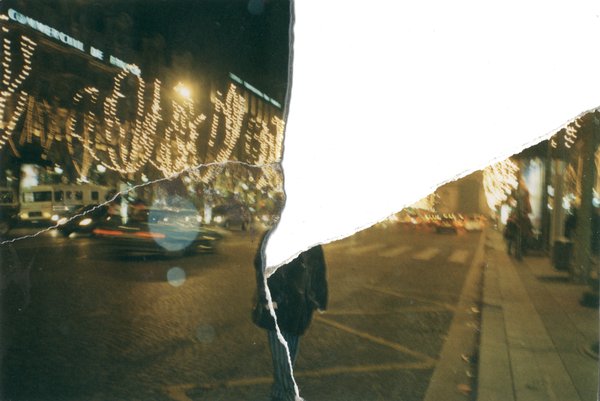 Avenue de nuit et arbres avec décorations de noël. Image déchirée en partie reconstituée.