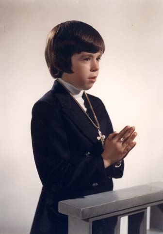 Petit garçon brun en communion.