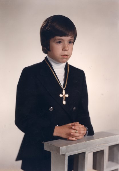 Petit garçon brun en communion.