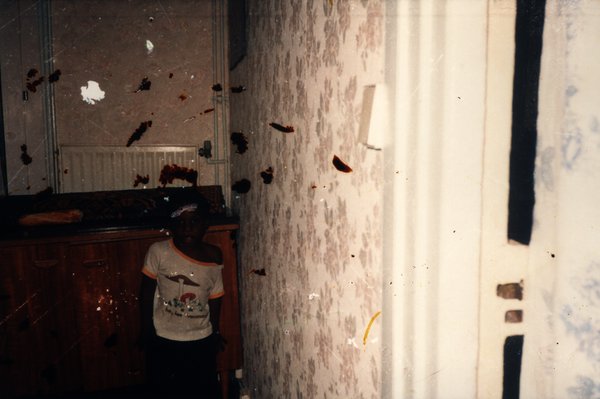 Enfant près d'un meuble dans une pièce. Image avec taches sombres.ᴬᴵ