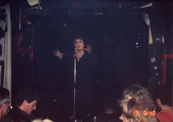 Transformiste en Edith Piaf sur une scène face à un public.