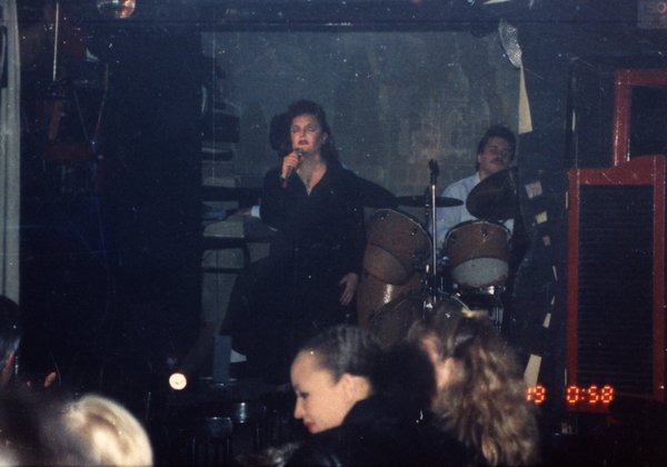 Transformiste en Edith Piaf sur une scène face à un public.