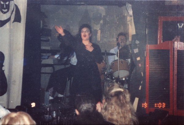 Transformiste en Edith Piaf sur une scène face à un public.