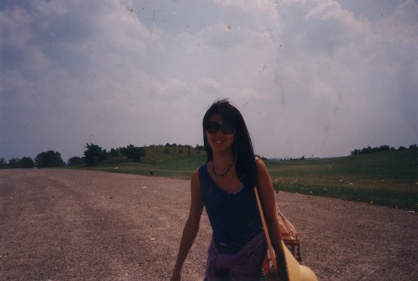Femme debout sur une route devant un paysage.