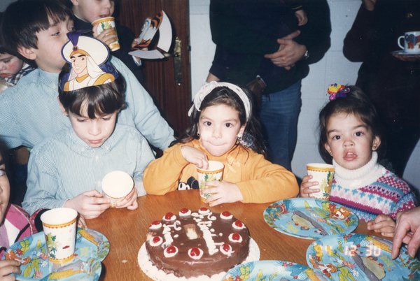Goûter d’anniversaire avec enfants coiffés de chapeaux et gâteau au chocolat.