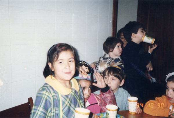Goûter d’anniversaire avec enfants devant des gobelets en carton.