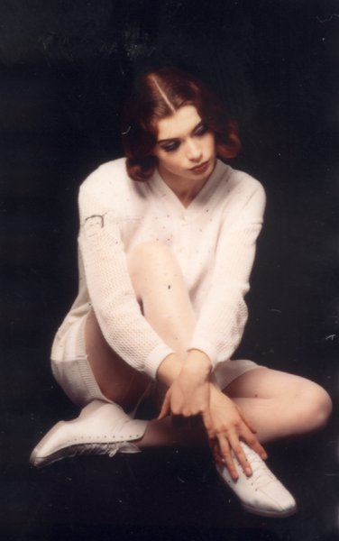 Mannequin posant assise en tenue et bottines blanches.