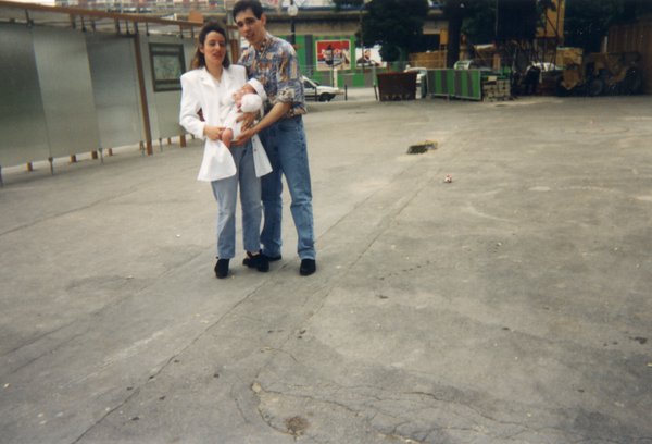 Homme et femme dans la rue avec un bébé dans les bras.