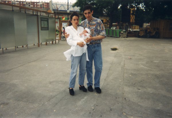 Homme et femme dans la rue avec un bébé dans les bras.