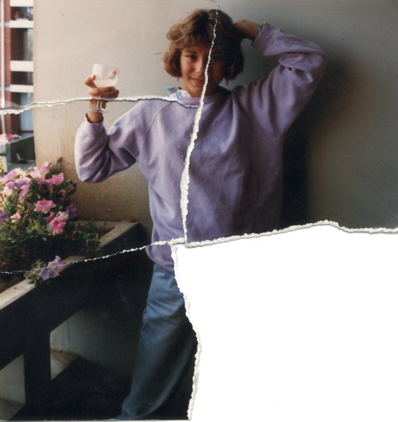 Jeune fille blonde un verre à la main debout sur un balcon avec des jardinières. Image déchirée en partie reconstituée.