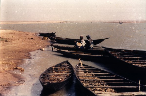 Étendue d’eau avec pirogues et femmes.